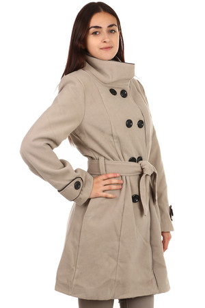 Dłuższy płaszcz z kontrastowym wykończeniem i dwoma rzędami guzików w kolorze jasnobeżowym. Posiada zapięcie na